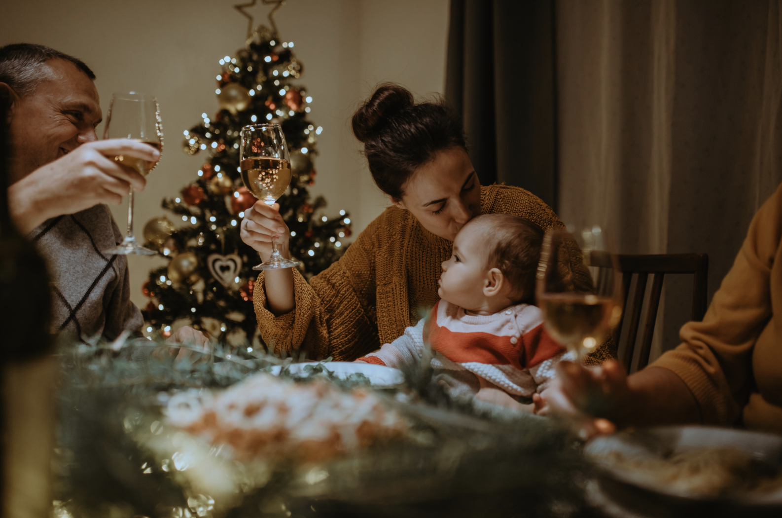 family sat around table at Christmas