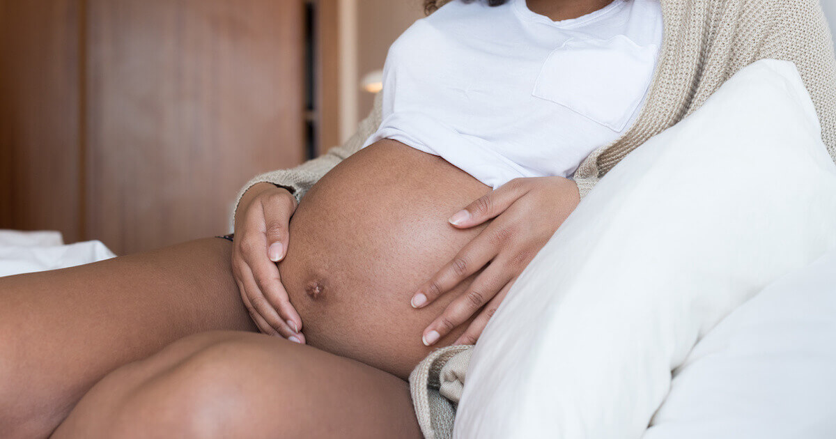 black pregnant woman holding her belly