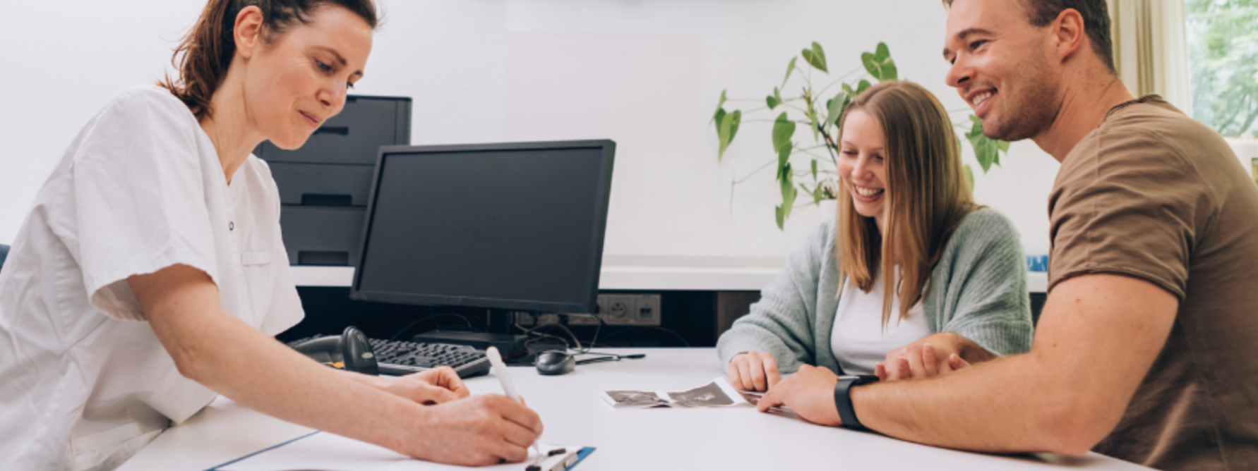 pregnant couple sat at a midwife appointment