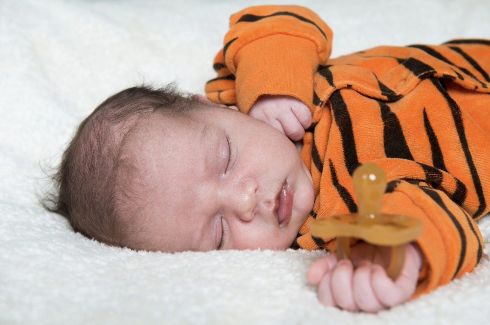 baby laying down with comforter