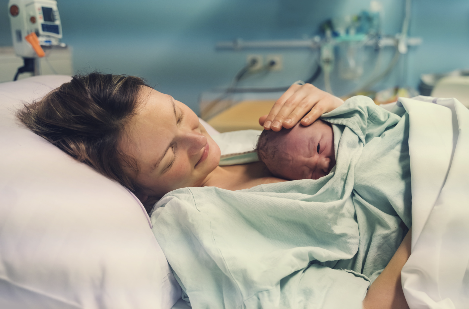 newborn baby laying on mothers chest in hospital