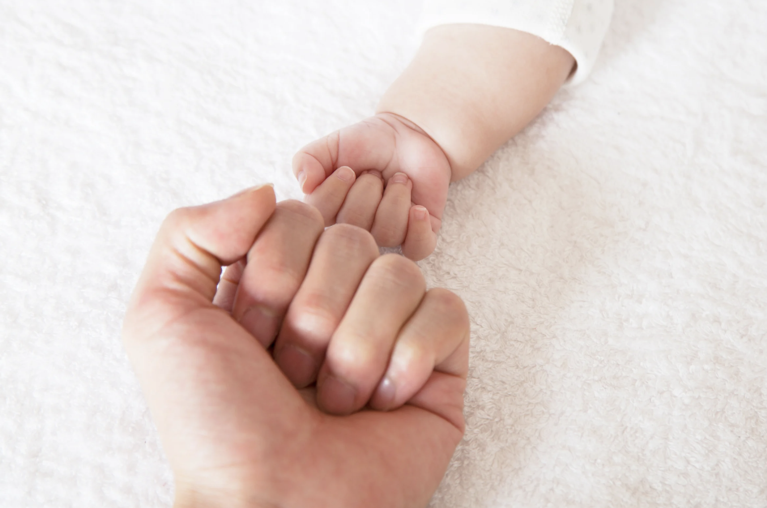 fathers hand and baby hand touching in a fist
