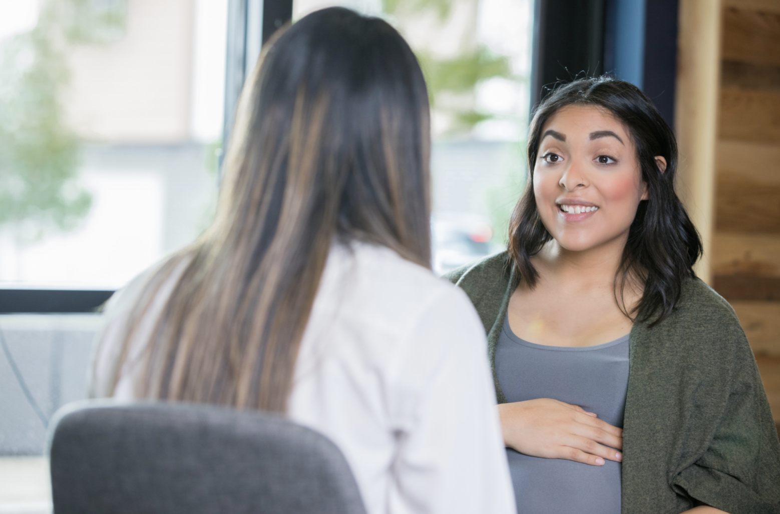 pregnant woman sat talking to doctor