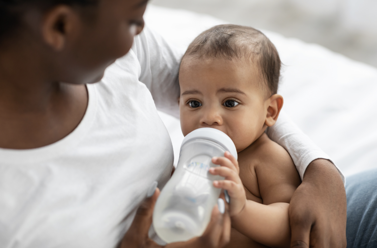 woman bottle feeding baby