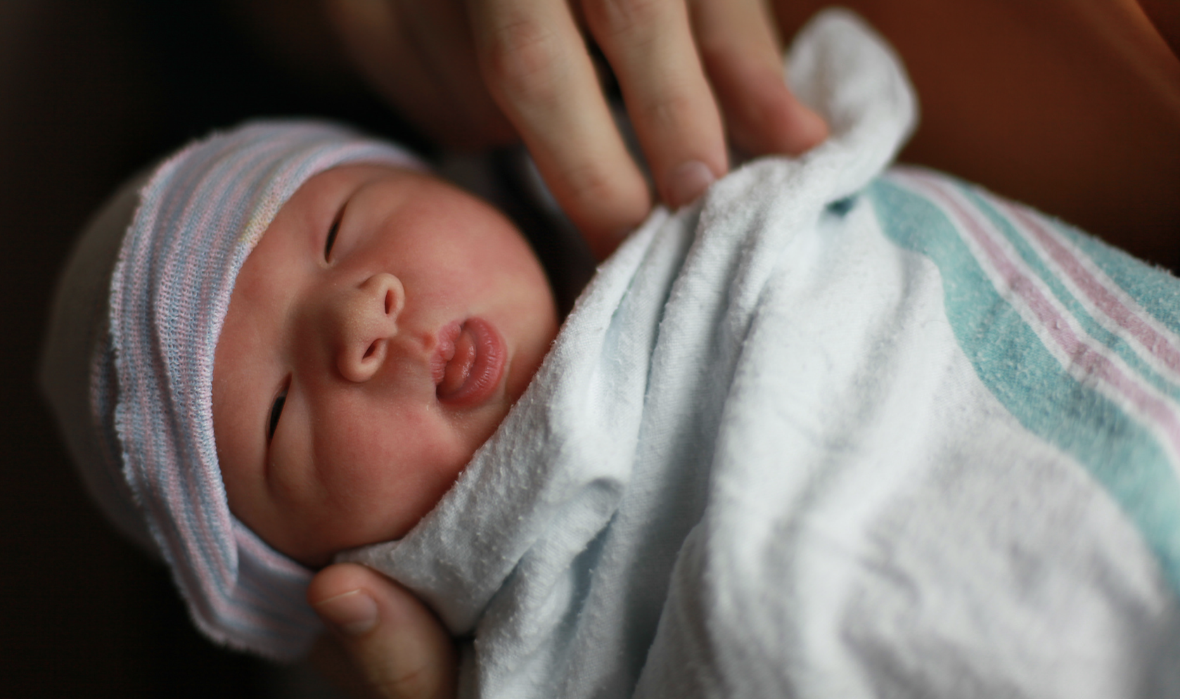 newborn baby poking out tongue