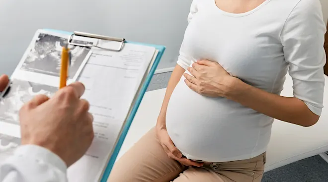 Pregnant woman at antenatal appointment discussing Bishop score with doctor