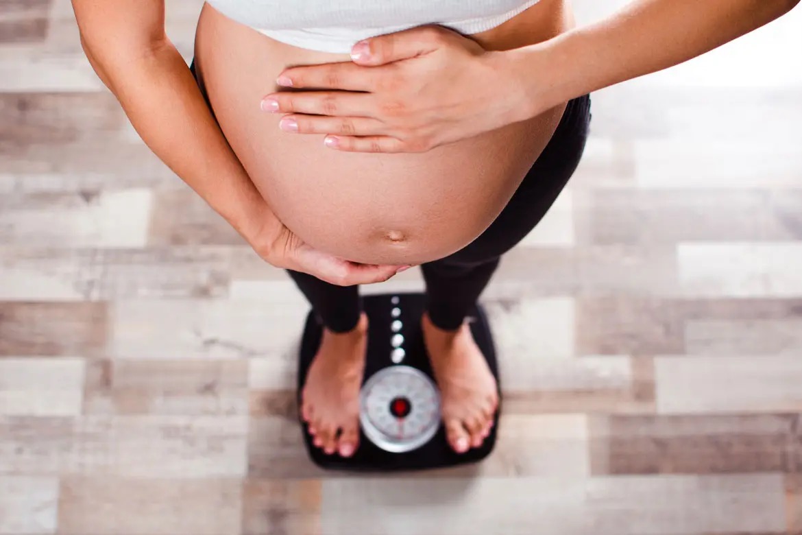 pregnant woman stood on scales